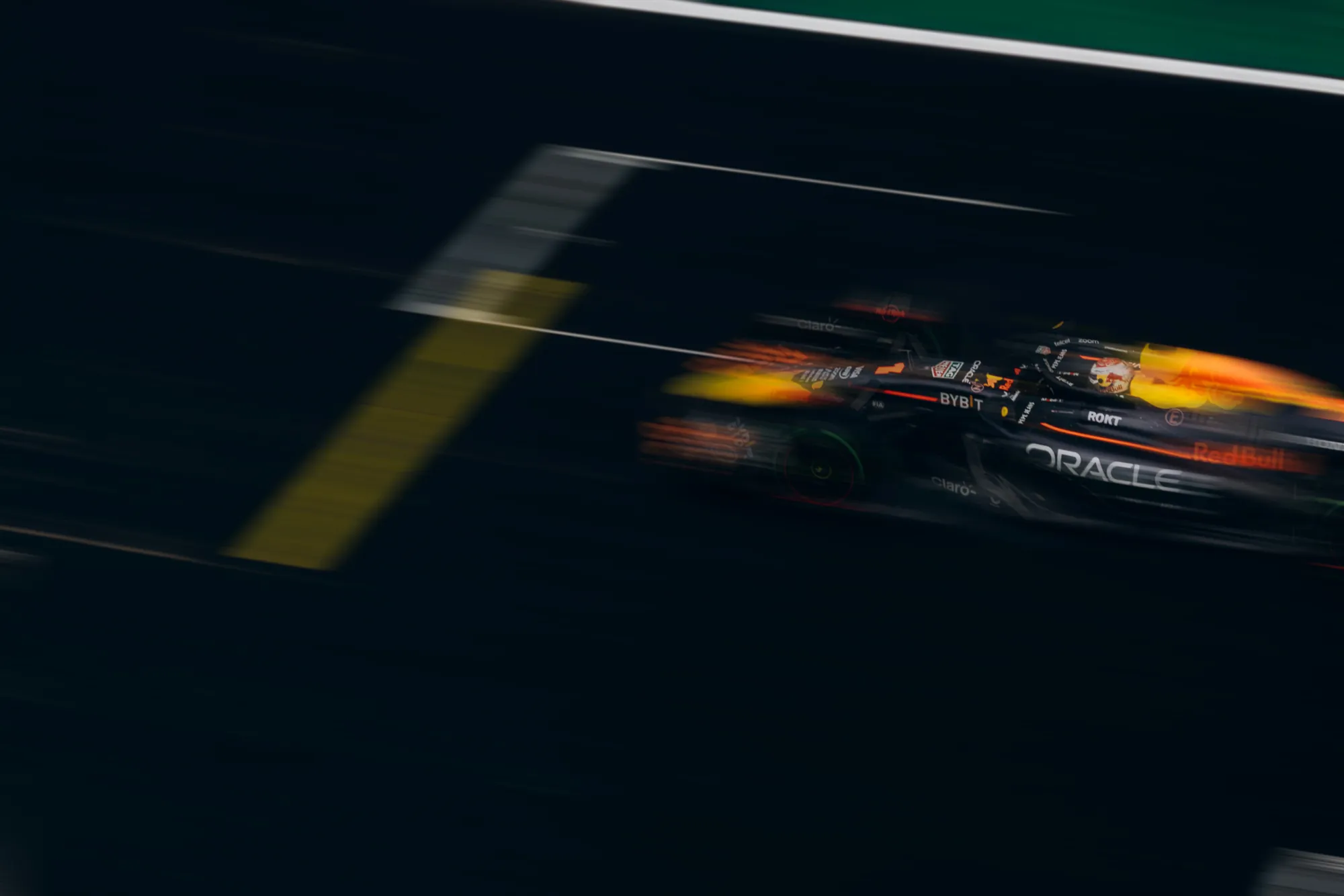 A Formula 1 car streaking past at night, blurred by speed